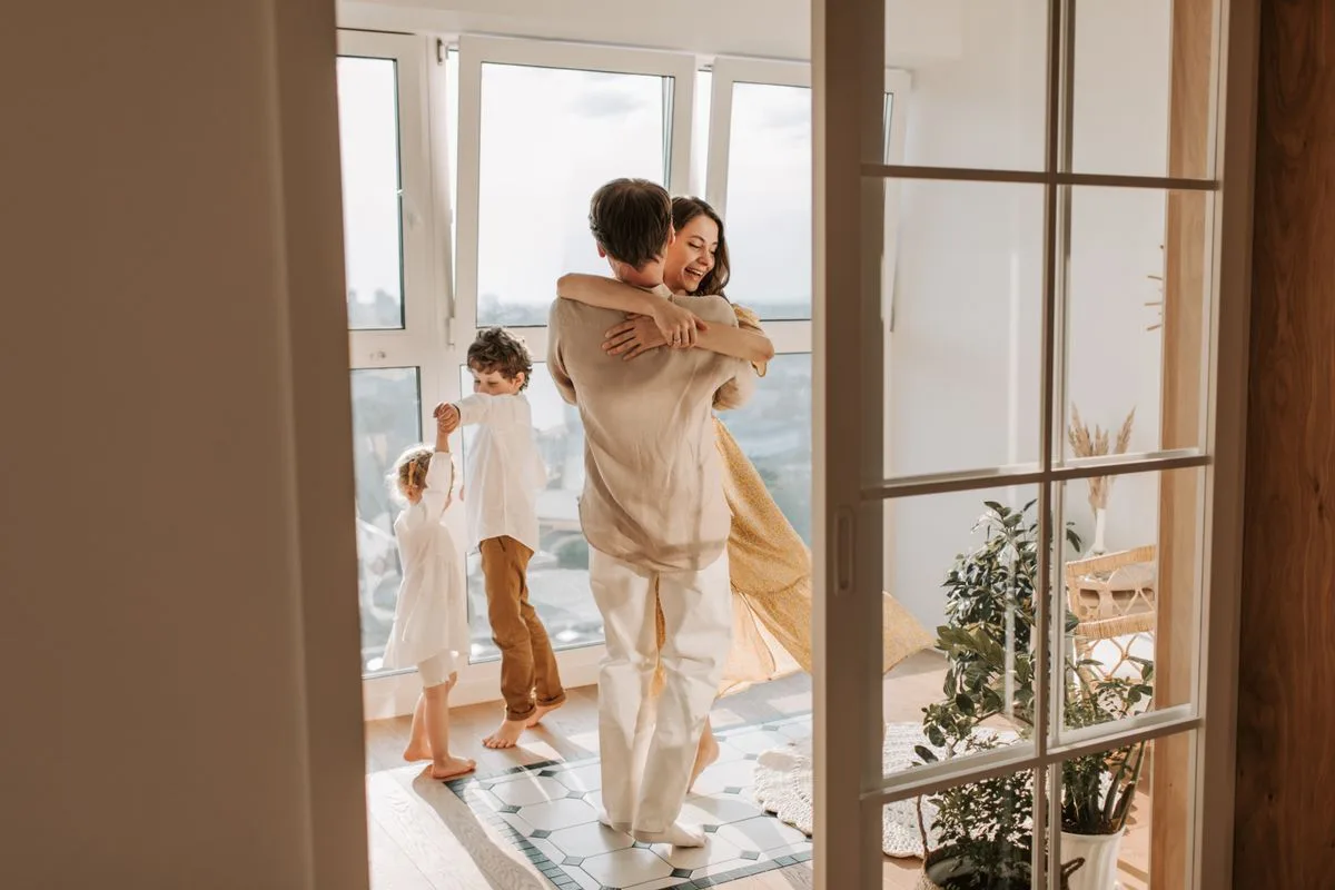 Happy family enjoying a moment of togetherness and joy while dancing in their living room.