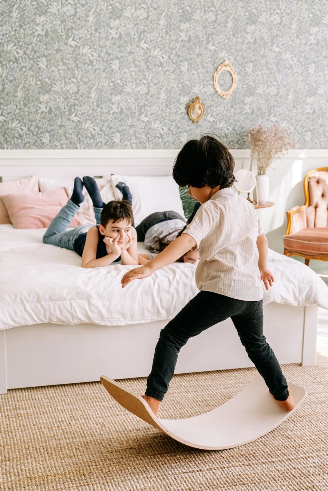 Two children playing in a cozy bedroom, enjoying fun and relaxation indoors.