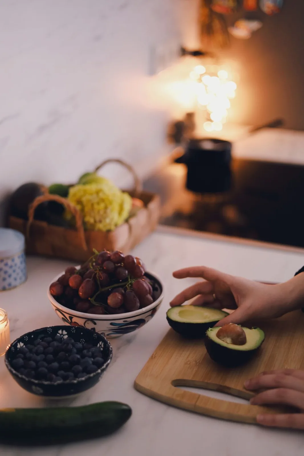 A cozy kitchen with fresh fruits and avocado preparation on a wooden cutting board in Berlin, Germany.