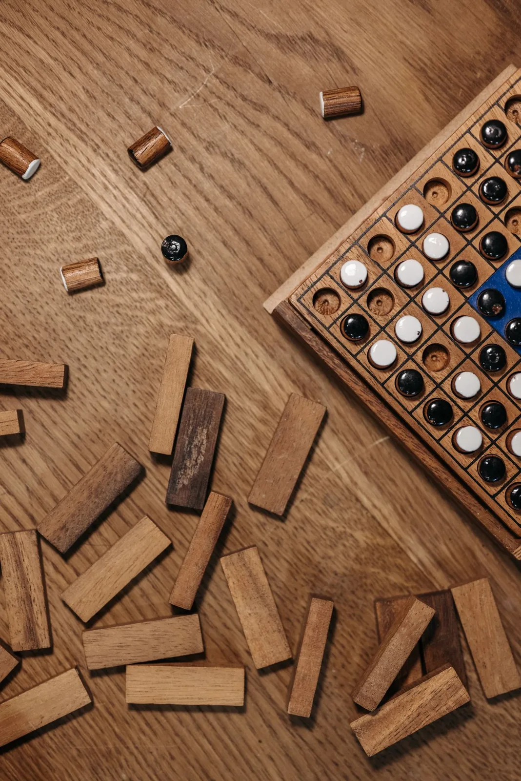 Wooden board game with pieces and blocks on a wooden table, ready for play.