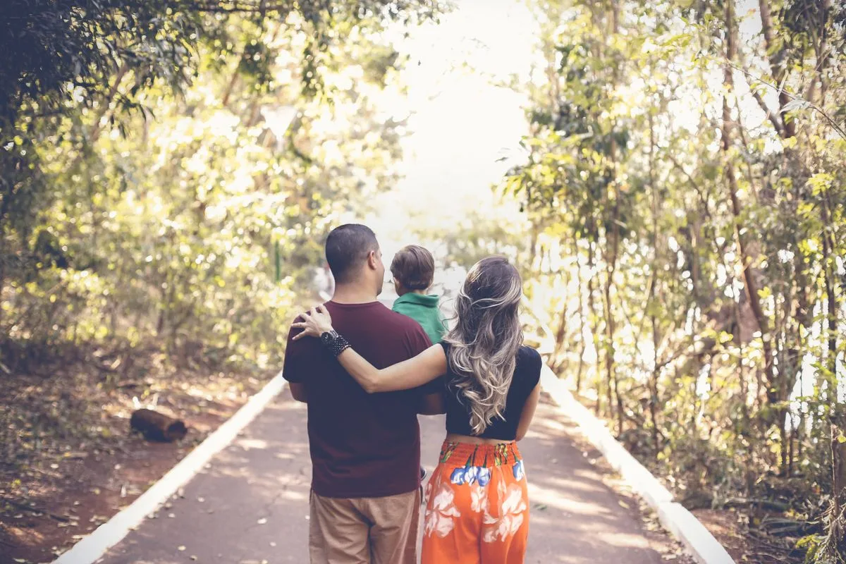 A family enjoying a leisurely walk on a sunny park trail.